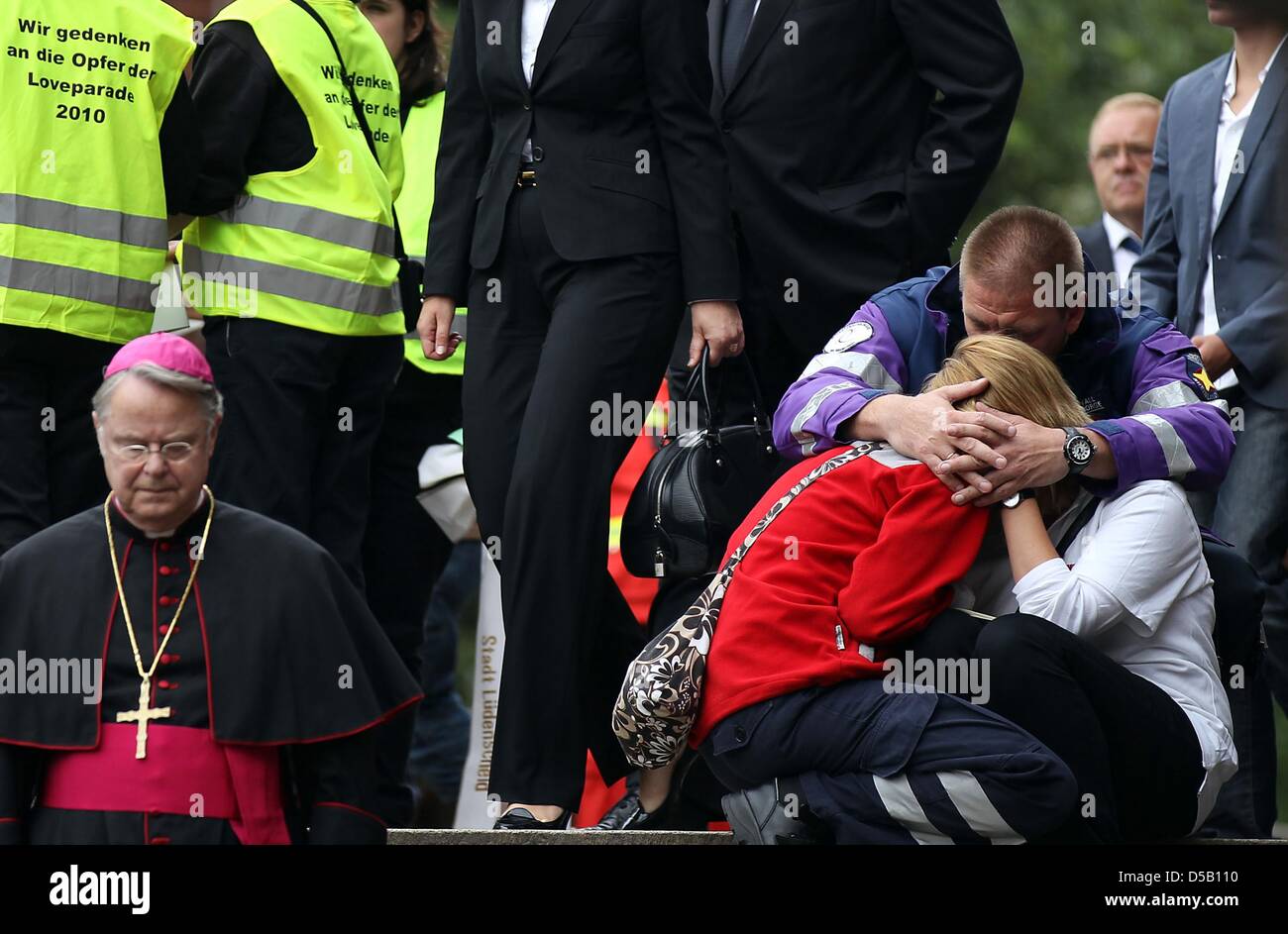 An emergency counselor takes care of two crying rescue workers, who ...