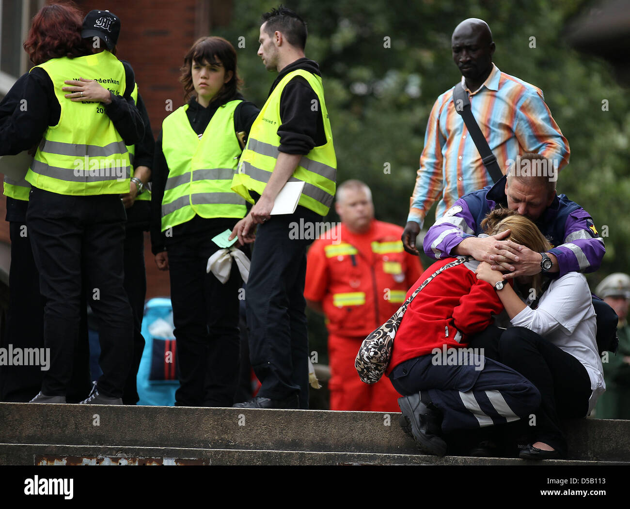 An emergency counselor takes care of two crying rescue workers, who ...