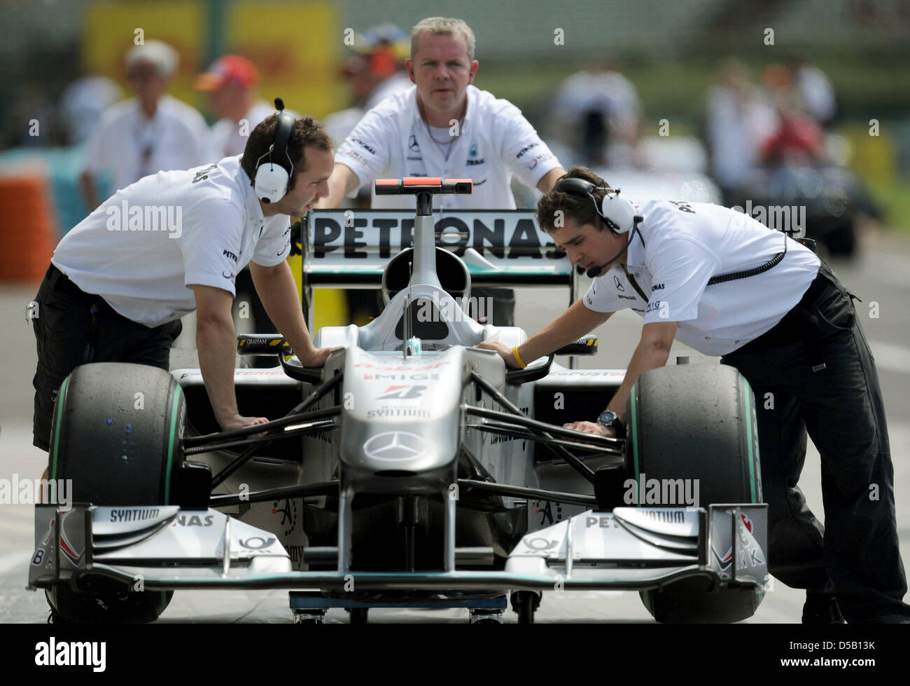 Mercedes GP mechanics push German race driver Michael Schumacher's car