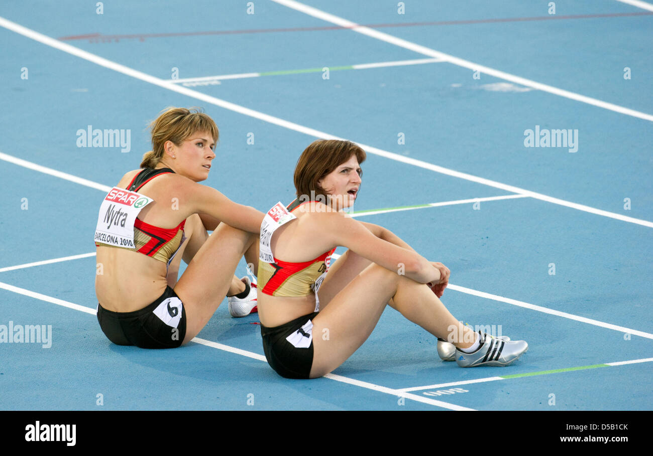 The German hurdler Carolin Nytra (L) wins the bronze medal  and sits on the track with German sprinter Nadine Hildebrand at the European Athletics Championships at Olympic stadium Lluis Companys in Barcelona, Spain, 31 July 2010. Derval O`Rourke won second place. Nadine Hildebrand won eigth place. Photo: Bernd Thissen Stock Photo