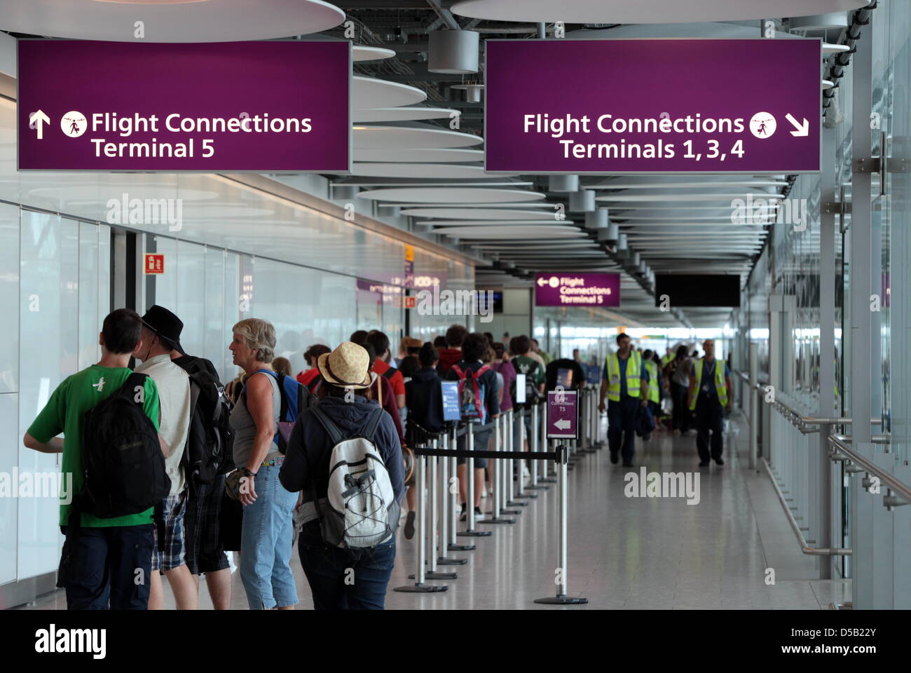 Voyagers stand in a hallway that connects terminal 5 to other terminals