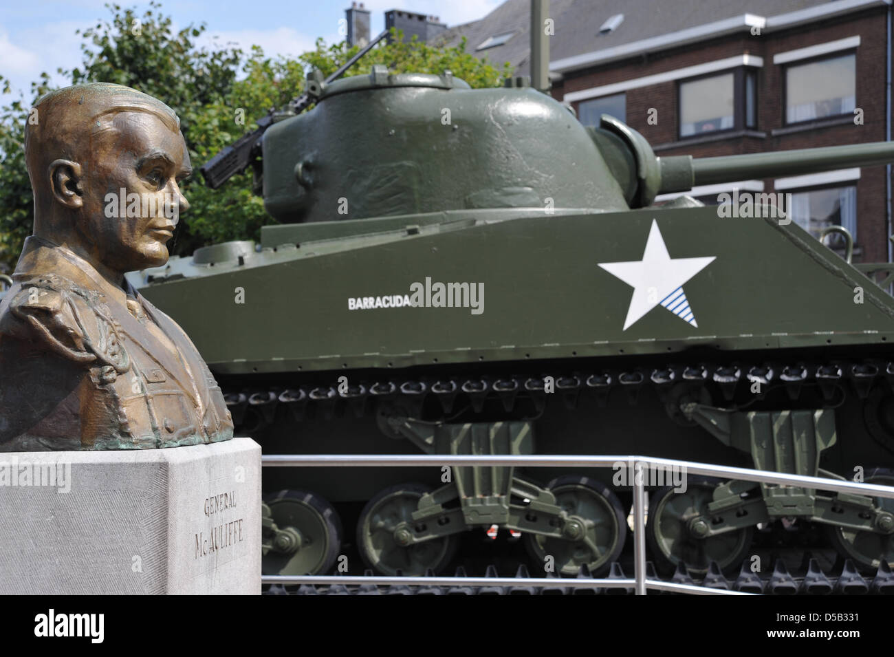 A Sherman tank and the General McAuliffe memorial pictured on the McAuliffe square in Bastogne, Belgium, August 2009. US army General Anthony Clement McAuliffe was a war hero of the battle in Bastogne and became famous for answering ?Nuts? to the German demand for capitulation on 22 December 1944. The allied victory in Bastogne is considered a turning point in Word War II and opene Stock Photo