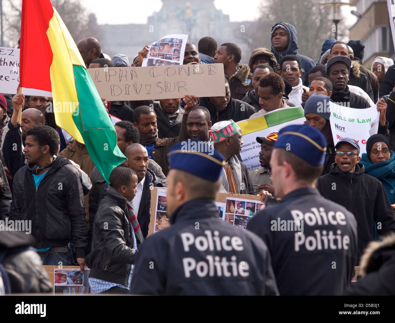 Policemen watching people protesting against dictator Alpha Conde of Guinea Stock Photo