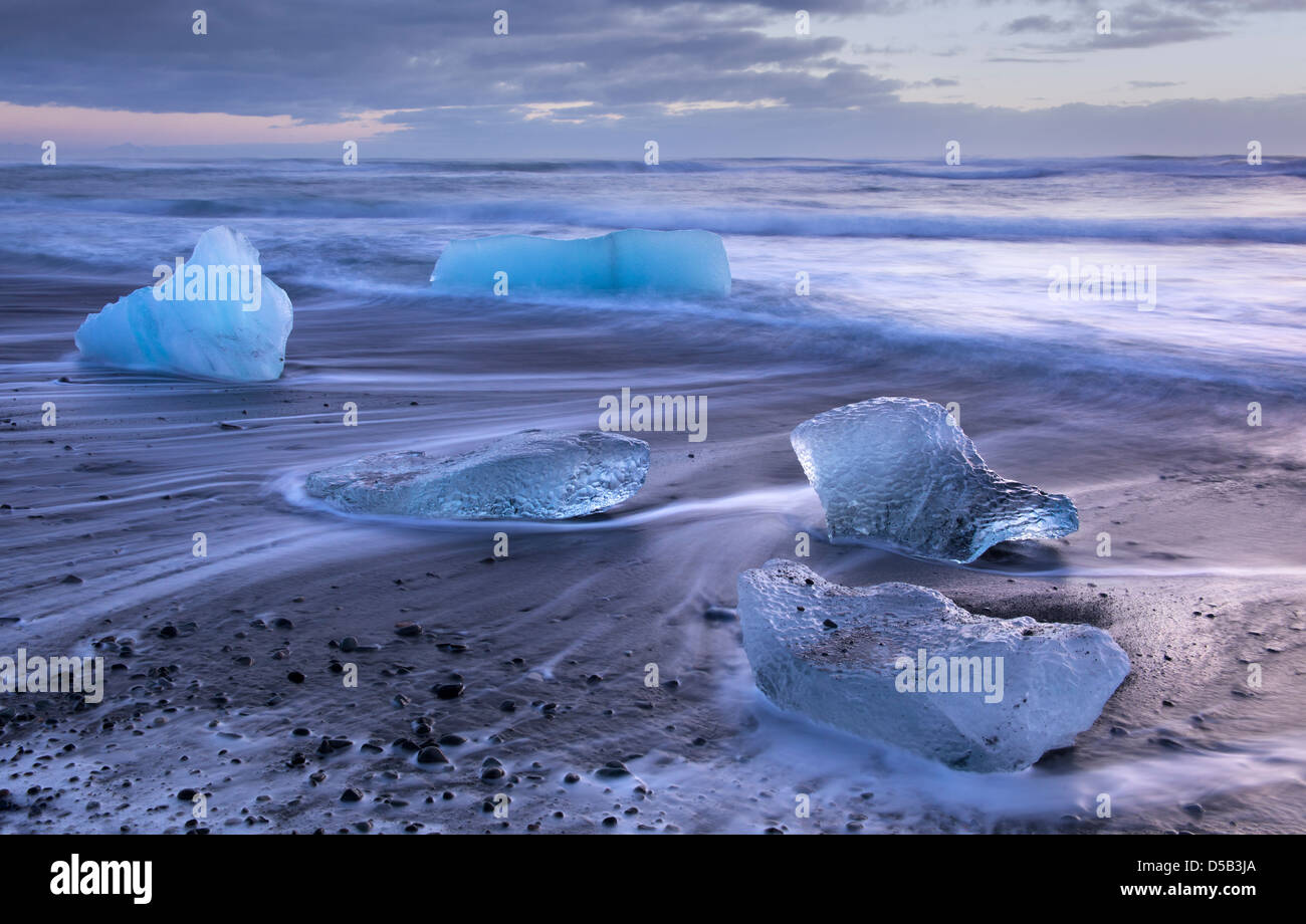 Ice blocks washed ashore on a sand beach. Near Jökulsarlon glacier bay, Southern Iceland. Stock Photo