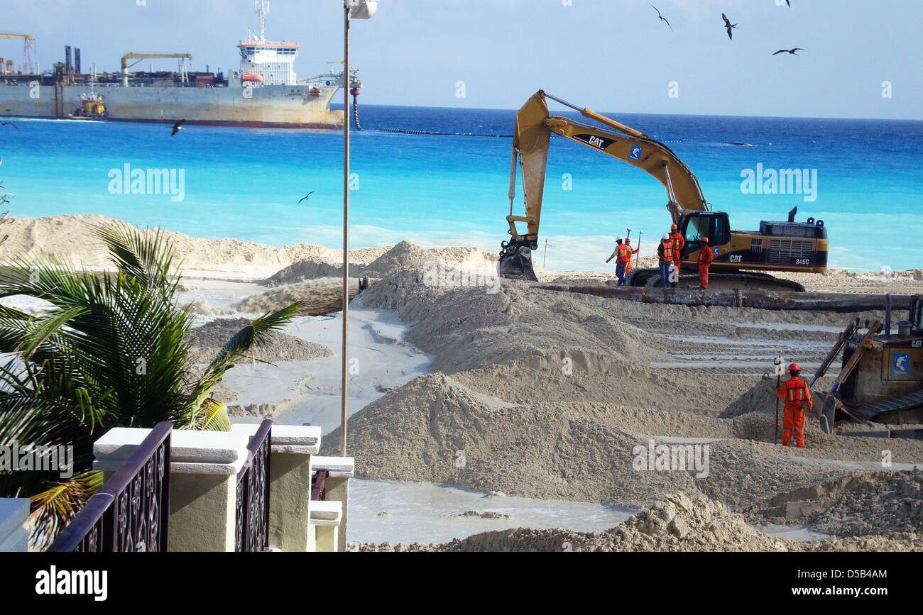 Diggers scatter white sand on the beach in Cancun, Mexico, 10 December 2009. A suction dredger in the back has transported thousands of cubic metres of sand from Cozumel island to Cancun. Hurricanes have washed away the sand again and again. Photo: Franz Smets Stock Photo