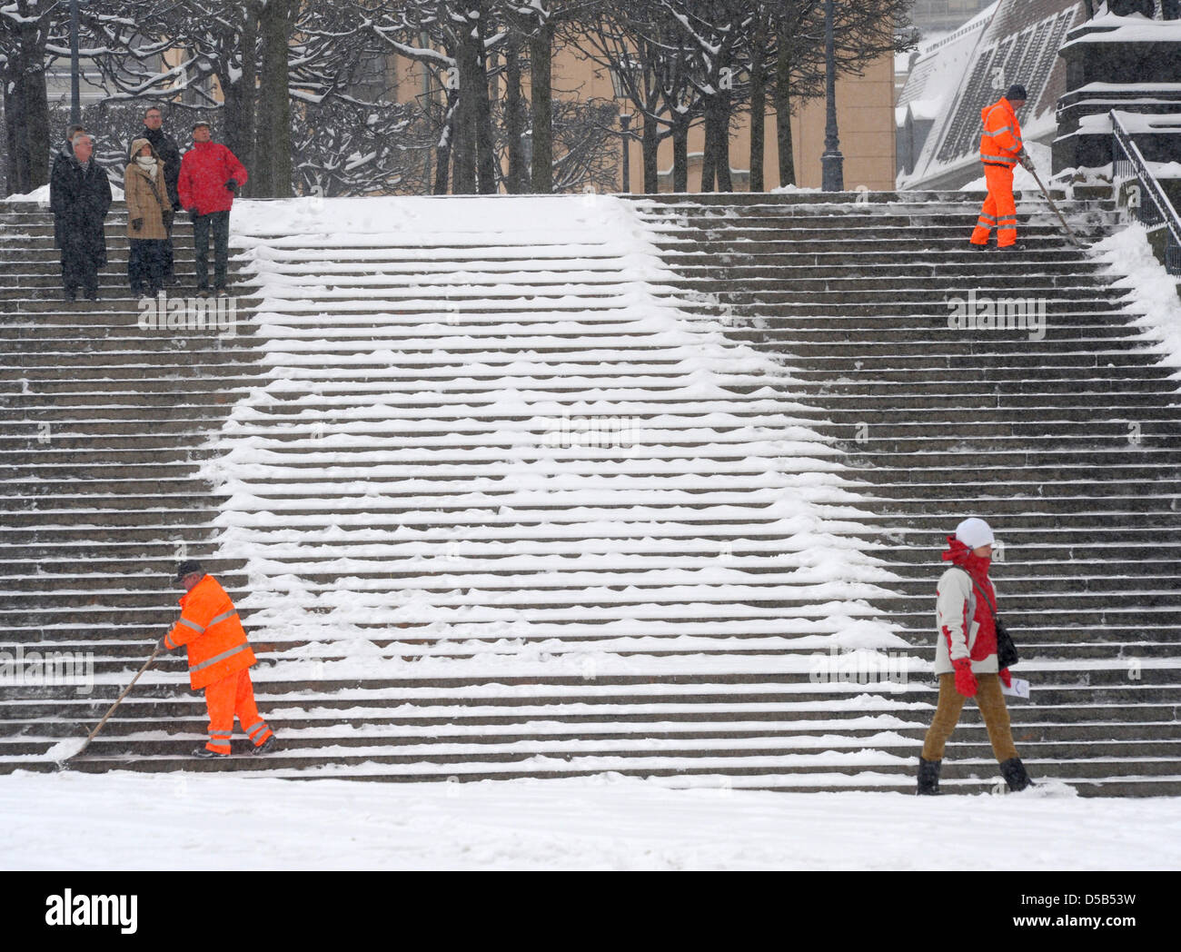 Staff members of the city cleaning clear stairs of the snow in Dresden