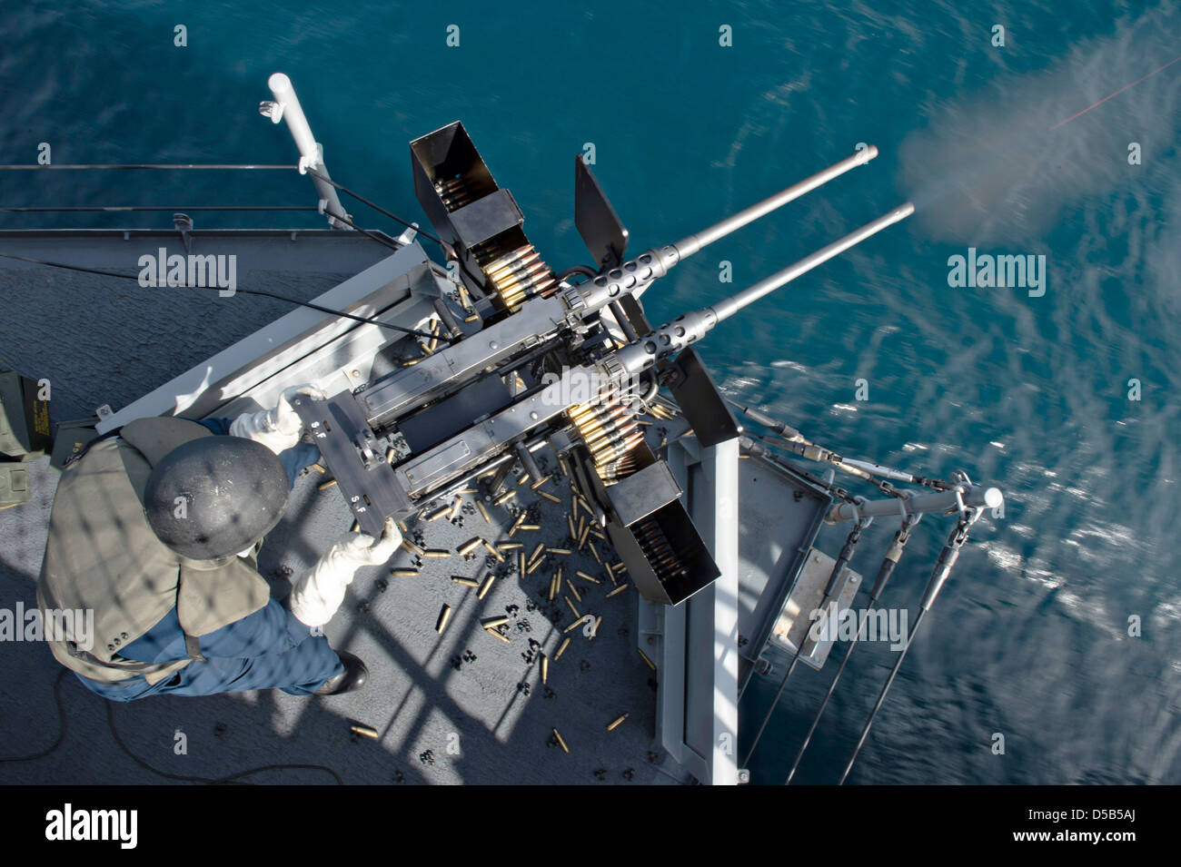 A US Navy sailor fires twin .50 caliber machine guns during a live-fire ...