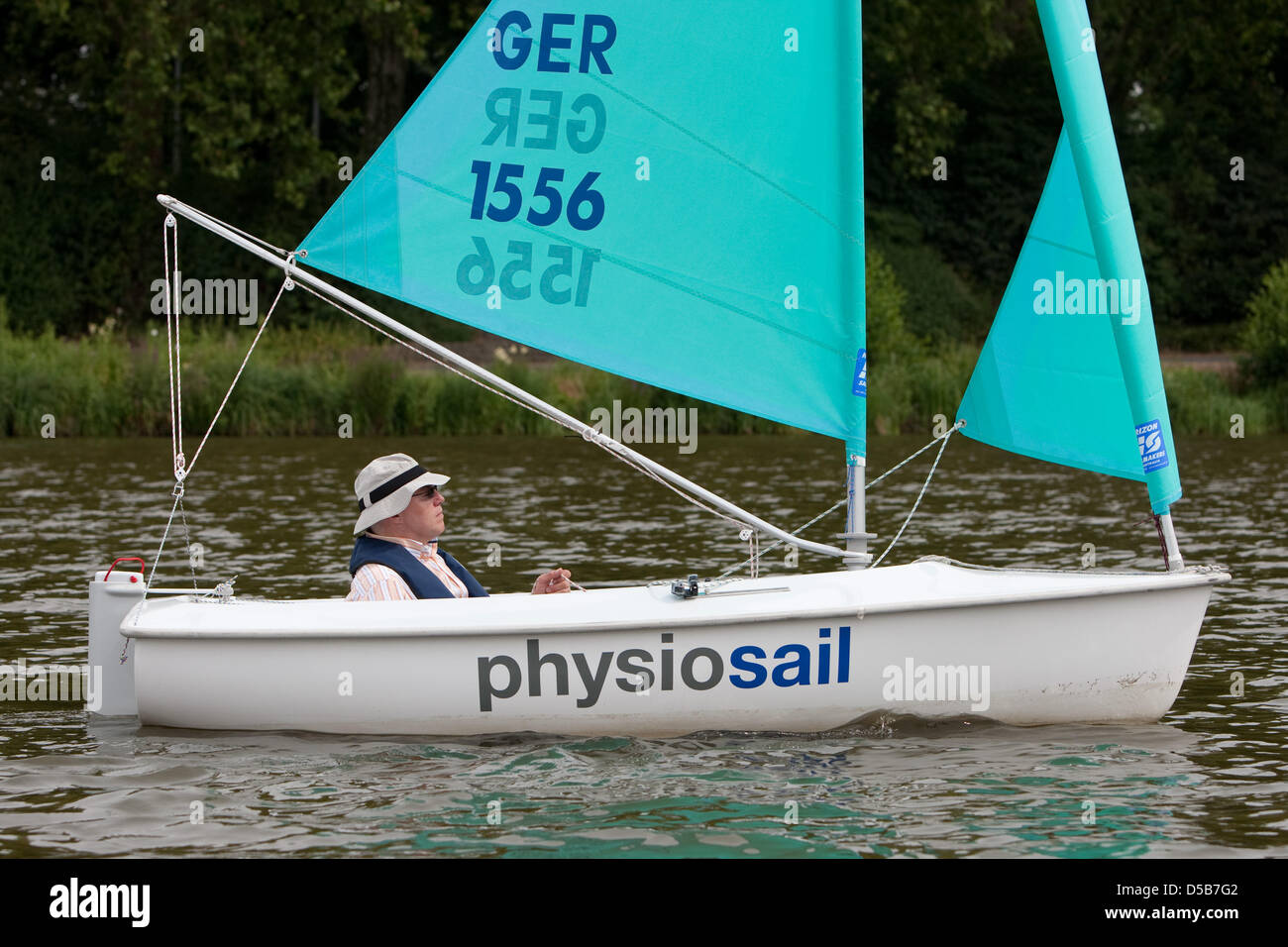 Hemiplegic Klaus Dinter sails with the 'Access Dinghi' on the Aasee near Muenster, Germany, 01 July 2010. Germany's only sailing therapy school 'physiosail' offers sailing therapy for the handicapped. Photo: Friso Gentsch Stock Photo