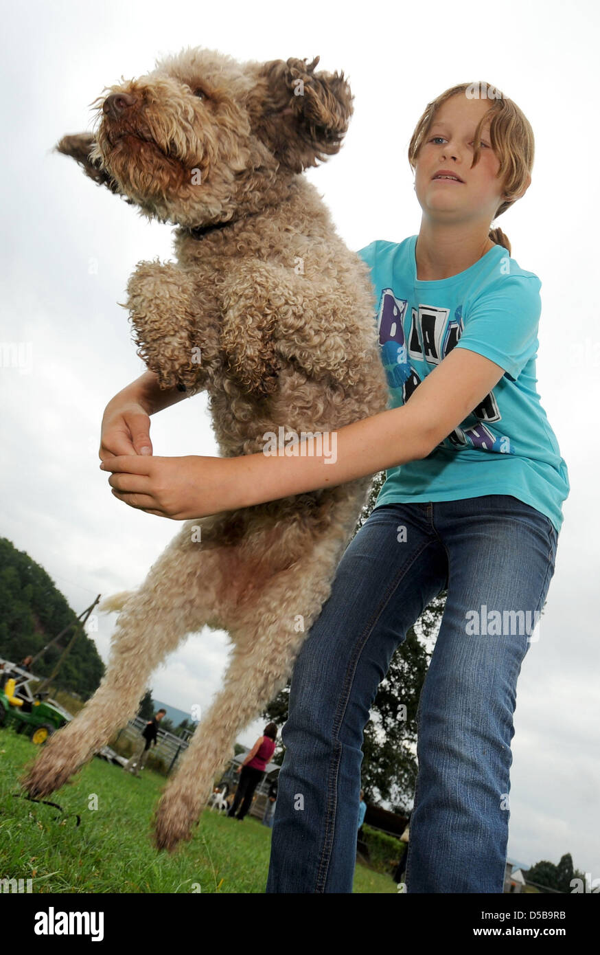 A dog jumps through its owner's arms at a 'Dogdancing' session in