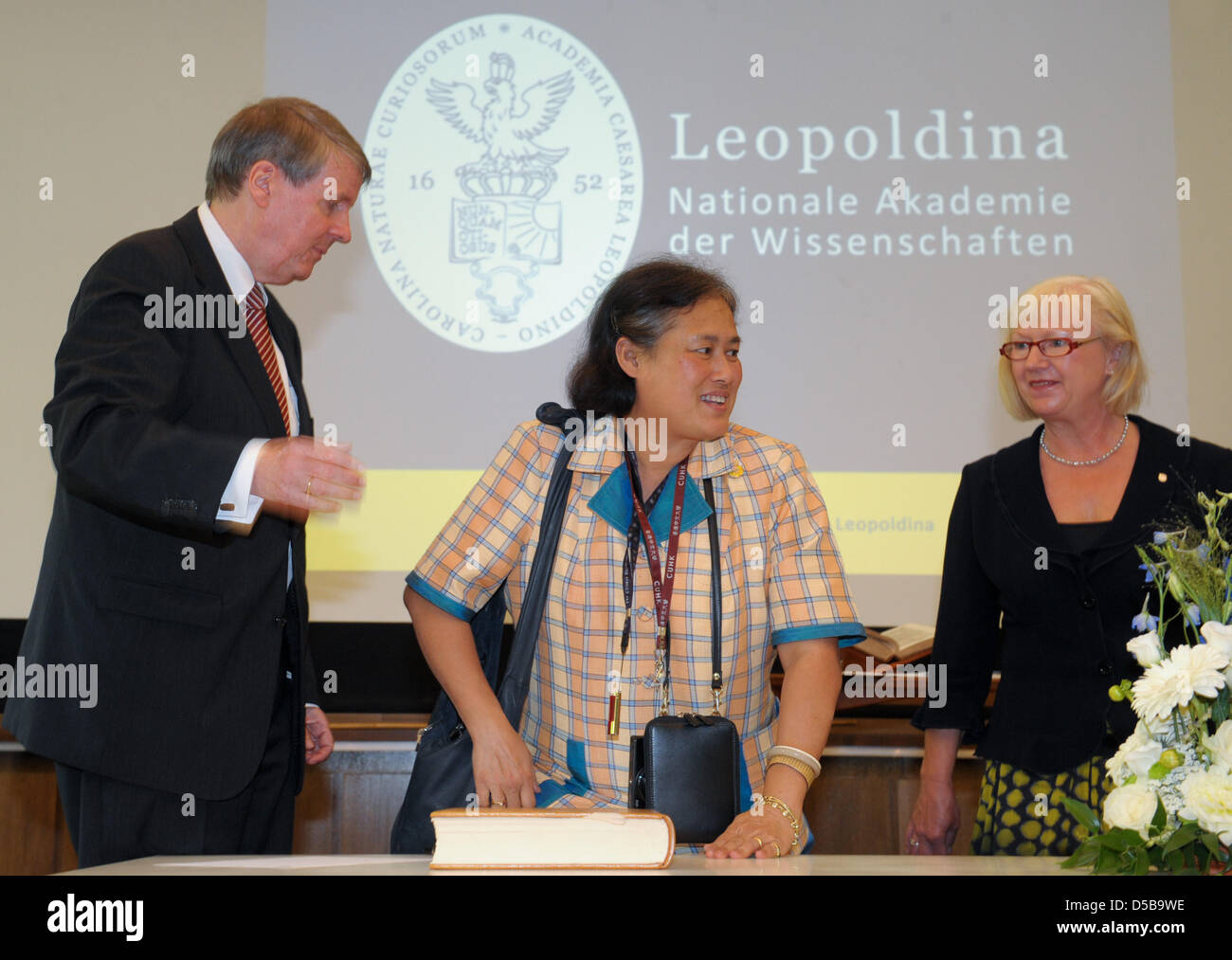 Thai Princess Maha Chakri Sirindhorn (C) signs the guestbook of German Academy of Science Leopoldina in company of Joerg Hacker (L), President of Leopoldina, and Jutta Schnitzer-Ungefug (R), Secretary-General of Leopoldina, at the adacemy in Halle Saale, Germany, 16 August 2010. The Princess informs herself on the German education and research system as it is the Princess's main ar Stock Photo