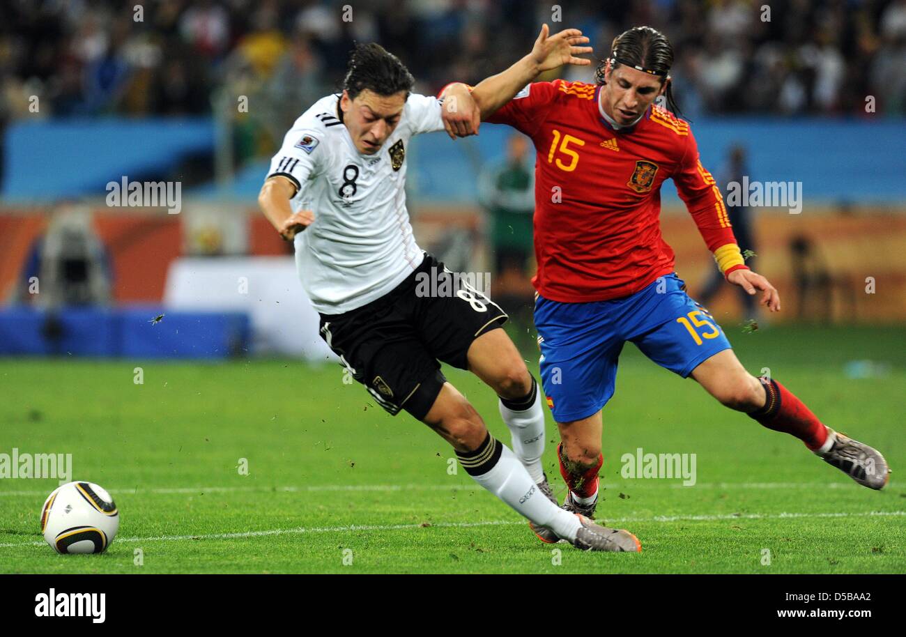 Germany international Mesut Ozil (L) and Spain international Sergio Ramos (R) vie for the ball during 2010 FIFA World Cup semi-final match Germany vs Spain in Durban, South Africa, 07 July 2010. On 17 August 2010, Oezil's club Werder Bremen confirmed that Germany midfielder Mesut Oezil will move from the Bundesliga club to Real Madrid. Bremen refused to state what size transfer fee Stock Photo