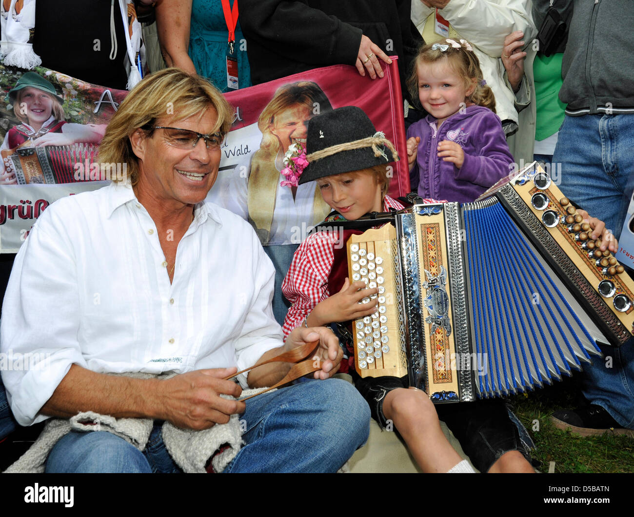 Austrian pop singer Hansi Hinterseer and thousands of his fans do the ...