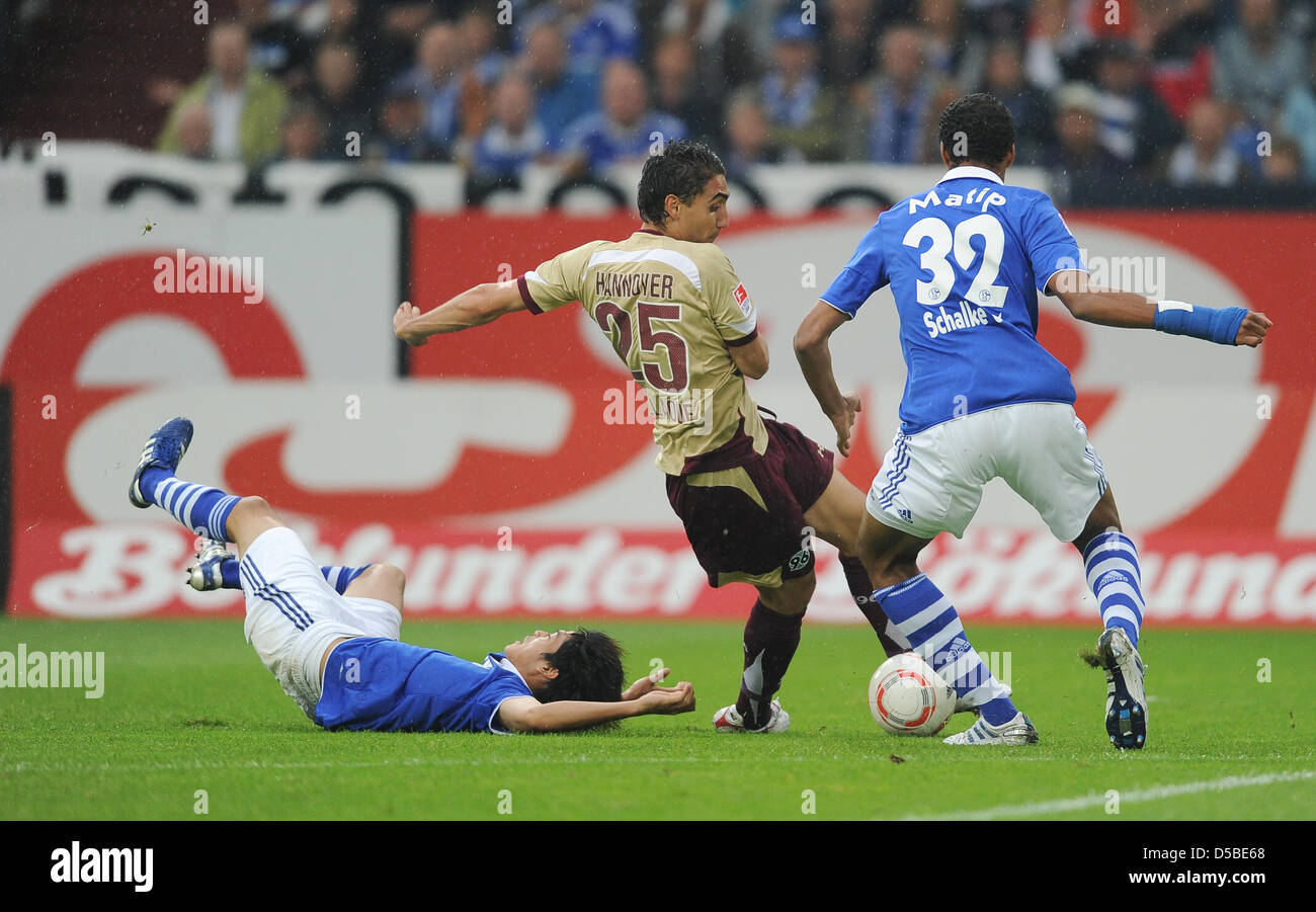 Schlake's Joel Matip (R)and Atsuto Uchida (L), as well as Mohammed Abdelaoue fight for the ball during the German Bundesliga match Schalke 04 vs. Hannover 96 in the Veltins Arena in Gelsenkirchen, Germany, 28 August 2010. Photo: Achim Scheidemann (ATTENTION: EMBARGO CONDITIONS! The DFL permits the further utilisation of the pictures in IPTV, mobile services and other new technologi Stock Photo