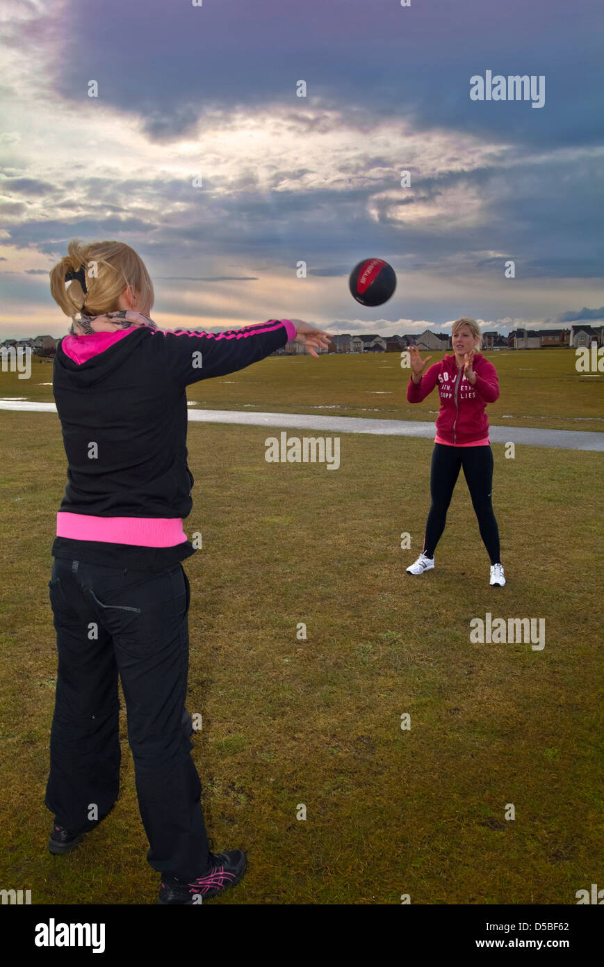 Two girls using a medicine ball stock photo alamy