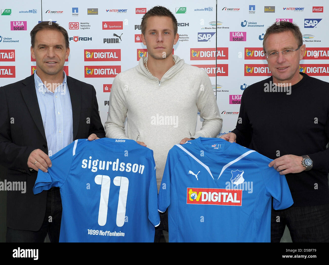 New player of German Bundesliga club 1899 Hoffenheim, Gylfi Sigurdsson from Iceland, presents his jersey with head coach Ralf Rangnick (R) and general manager Ernst Tanner (L) in Zuzenhausen, Germany, 31 August 2010. The 20 year-old was transferred from English club FC Reading to Hoffenheim. Photo: Ronald Wittek Stock Photo