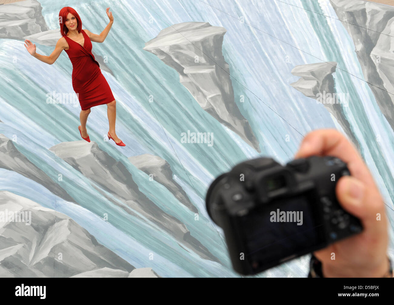 'Miss IFA' jumps from stone to stone in a 'waterfall' of the IFA fairground in Berlin, Germany, 1 September 2010. The extensive painting belongs to an installation that porovides a test area for 3D cameras. Organizers of the fair promise more new products than ever before  for the 50th edition of the IFA that takes place between 3-8 September 2010. According to the fair, more than  Stock Photo
