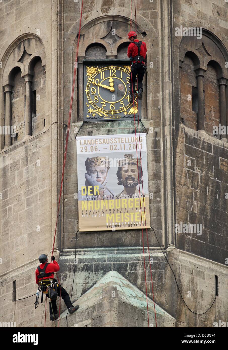 Two industrial climbers install a sign advertising the major regional exhibition of Saxony-Anhalt in 2011 at a tower of the dome in Naumburg, Germany, 02 September 2010. The sign measures three metres. The exhibition named 'The master from Naumburg - sculptor and architect in Europe's league of cathedrals' will be open from 29 June until 02 November 2011 in Naumburg. Photo: Jan Woi Stock Photo