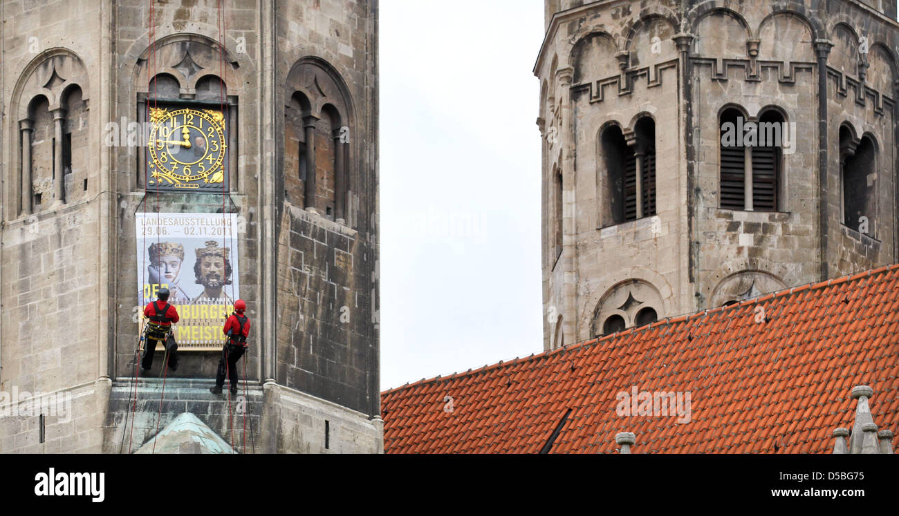 Two industrial climbers install a sign advertising the major regional exhibition of Saxony-Anhalt in 2011 at a tower of the dome in Naumburg, Germany, 02 September 2010. The sign measures three metres. The exhibition named 'The master from Naumburg - sculptor and architect in Europe's league of cathedrals' will be open from 29 June until 02 November 2011 in Naumburg. Photo: Jan Woi Stock Photo