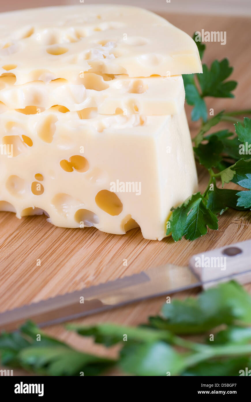 yellow cheese with large holes and parsley Stock Photo Alamy