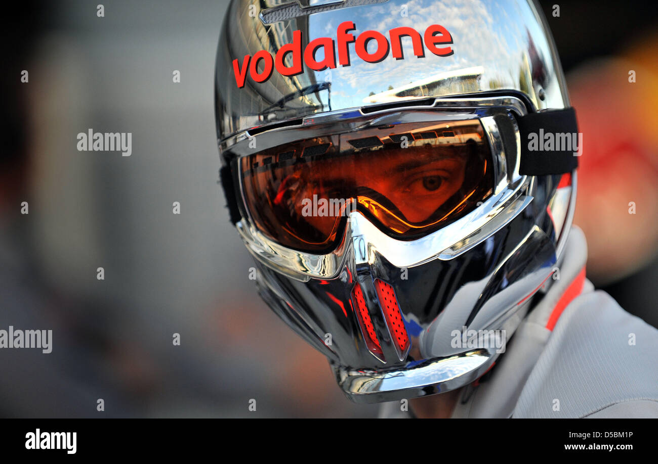 A mechanic of McLaren Mercedes wears a helmet prior to the first