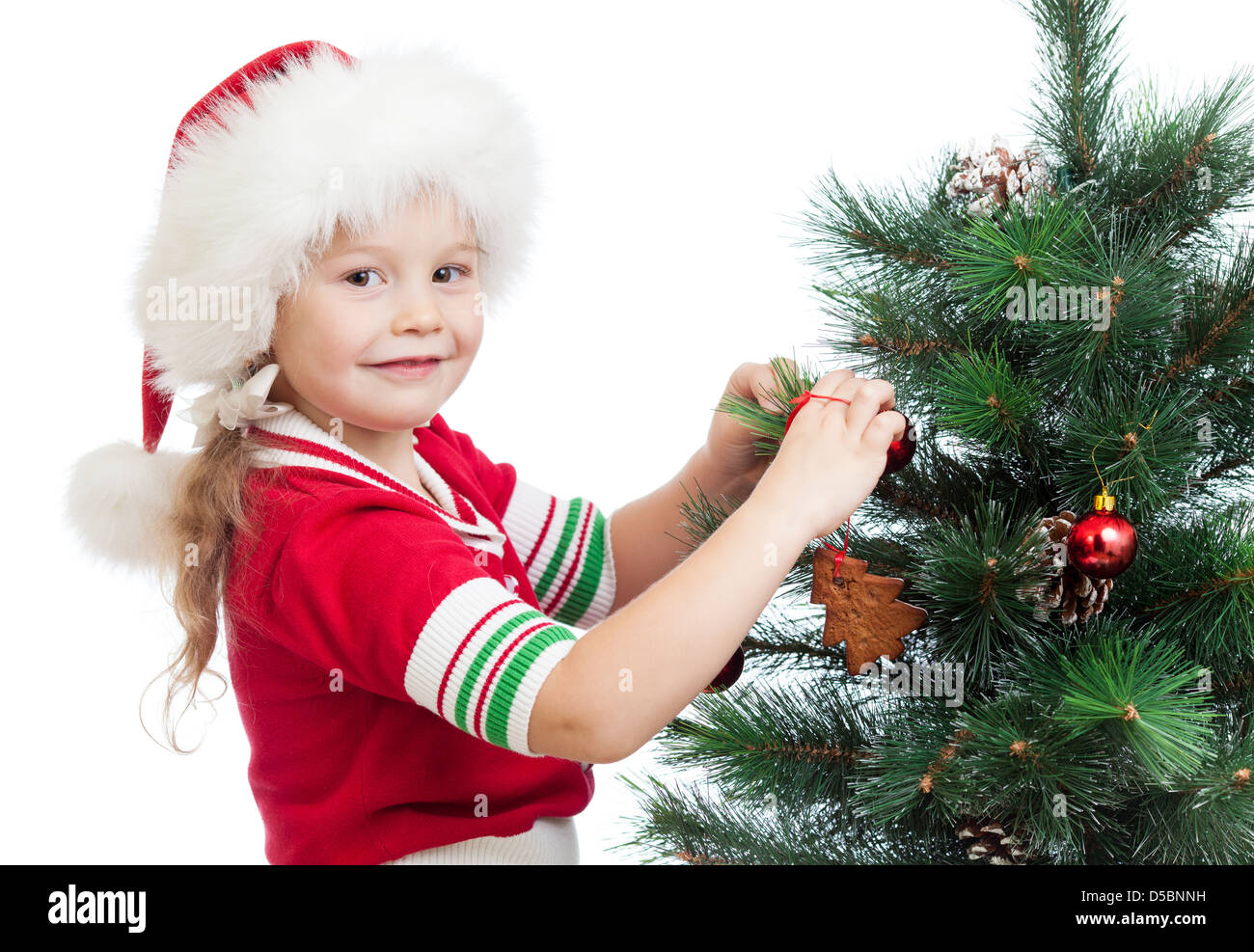 pretty preschool girl decorating Christmas tree isolated on white Stock Photo
