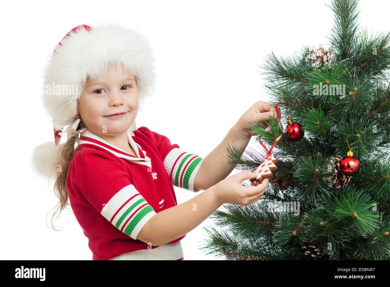 pretty preschool child decorating Christmas tree isolated on white Stock Photo