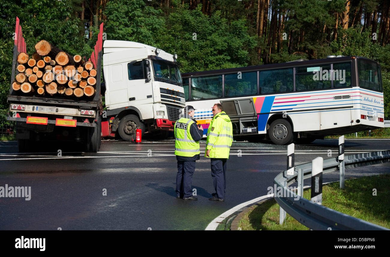 Two police officers examine the scene after a Polish lorry that carried tree trunks crashed with a coach on the Autobahn A13 near Freiwalde, Germany, 15 September 2010. According to information released by the police, 17 people were injured, four of them seriously. Photo: Patrick Pleul Stock Photo