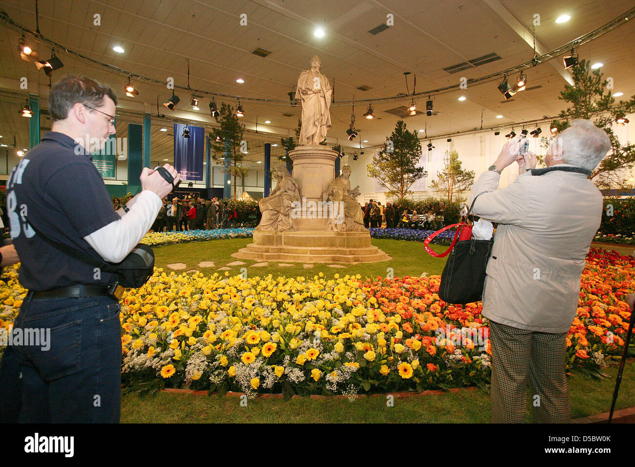 Visitors take photographs in the flower hall which this year's motto is