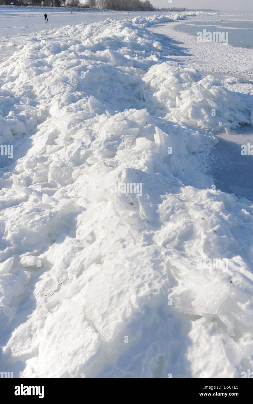 Tourists walk past ice waves at the beach of the coastal resort Lubmin