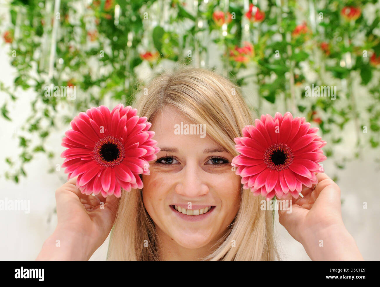 Model Anna poses with two red gerberas during a photo call promoting the international botanical and gardening fair IPM in Essen, Germany, 25 January 2010. IPM is a fair for professional visitors only and opens from 26 January to 29 January 2010. Some 1.500 exhibitors from 43 nations present their latest products in floristics, gardening and botanics. According to the organisers IP Stock Photo