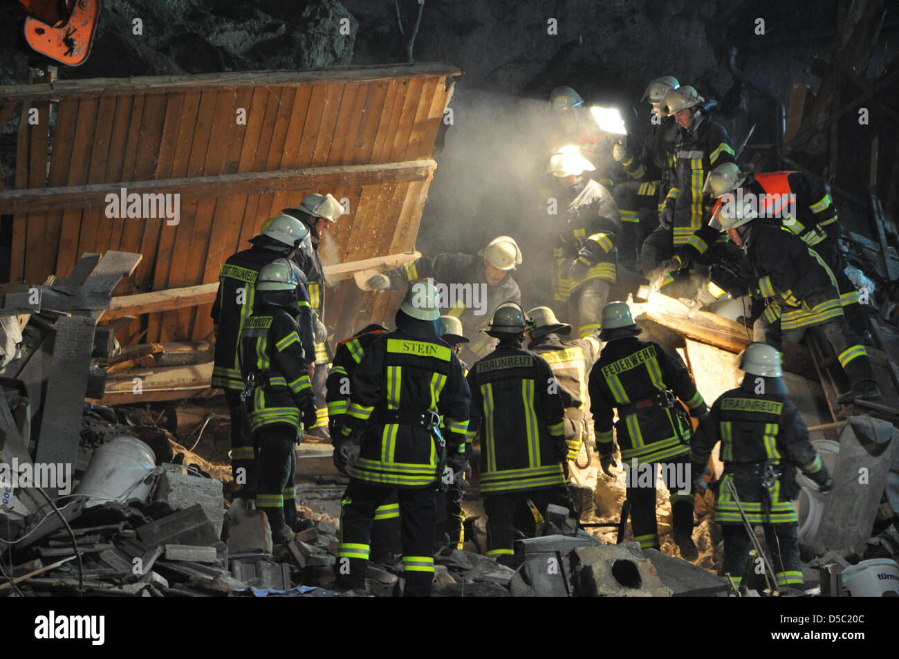 Fire fighters search for victims at the scene of the accident where a house was destroyed through a rockfall in Stein an der Traun, Germany, 25 January 2010. A massive rockfall onto an one family house killed a father and his 18-year-old daughter. The 40-year-old wife and mother, as also her 16-year-old son were rescued with injuries at the early morning. Photo: Grotemeyer Stock Photo