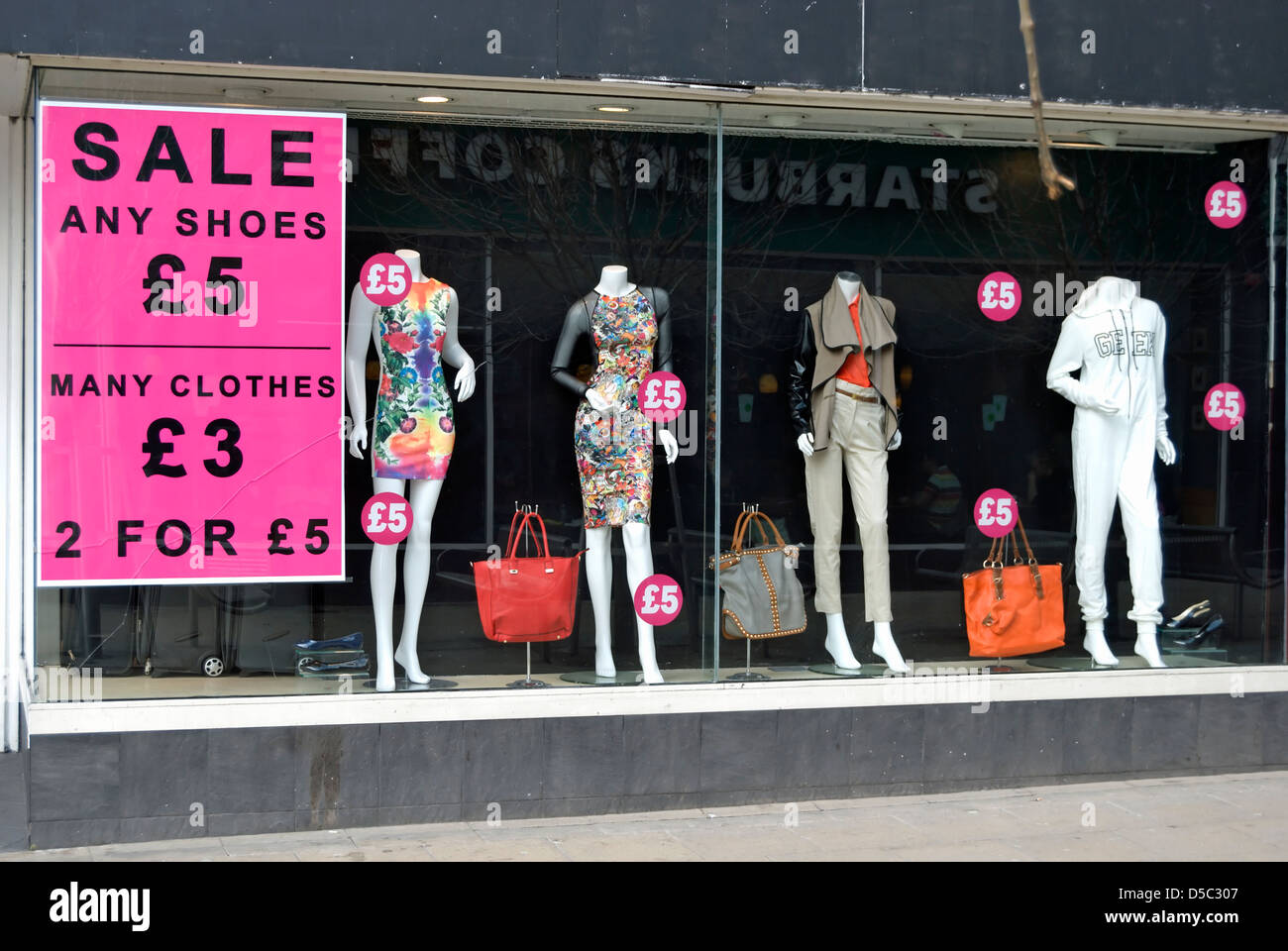 mannequins in a shop window in kingston upon thames, surrey, england, alongside sale signs Stock Photo