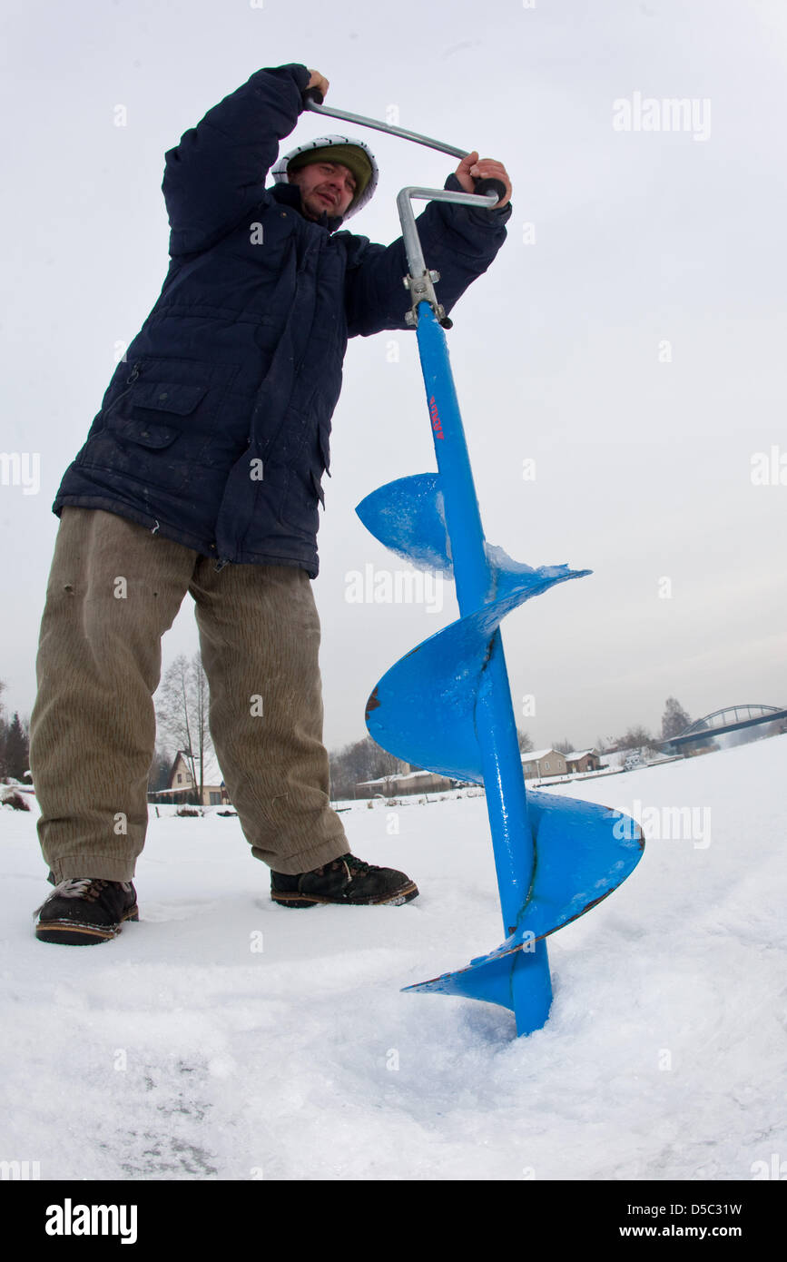 Ice fisher Danny Frohbert drills a hole into the 25-centimetre-thick ice on the frozen over Oder-Spree-canal in Muellrose, Germany, 27 January 2010. Photo: Patrick Pleul Stock Photo