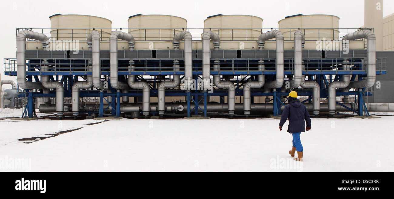 Technician Eckard Zingler cwalks through the snow in front of the gas coolers in the VNG underground gas storage in Bad Lauchstaedt, Germany, 27 January 2010. Integrated network gas corporation (VNG) stores arriving natural gas from mostly Russia here in 18 caverns and in a former natural gas repository, in order to deliver it equally into the German network. On the agenda of an ex Stock Photo