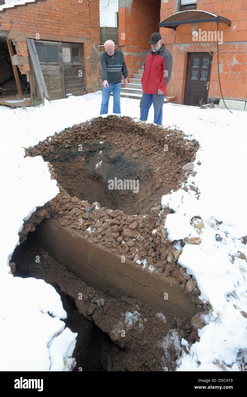 28.01.10/Erneut Erdfall in Tiefenort. Rund um den Betonpfropfen rutscht die Erde in die Tiefe. Grundstücksnachbarn schauen den Schaden an./  Heiko Matz  Hauptstraße 108  36433 Bad Salzungen  Tel. 0173/3903163  matzfoto@t-online.de  Veröffentlichung honorarpflichtig (7% Mehrwertsteuer) Veröffentlichung nur mit Namensnennung   Bankverbindung:  VR-Bank Bad Salzungen-Schmalkalden  Kto. Stock Photo