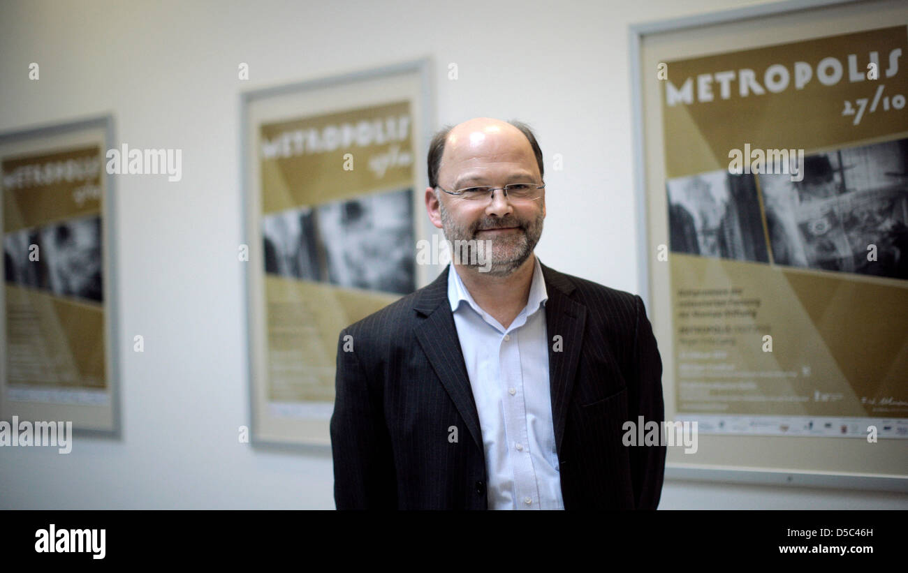 Helmut Possmann, head of Friedrich Wilhelm Murnau Foundation, smiles in front of a film poster of silent film classic 'Metropolis' by Fritz Lang in Wiesbaden, Germany, 29 January 2010. A press conference was held at Murnau Foundation on the occasion of the premiere of restored 'Metropolis' version in Frankfurt Main and Berlin on 12 February 2010. Missing parts of the film were disc Stock Photo
