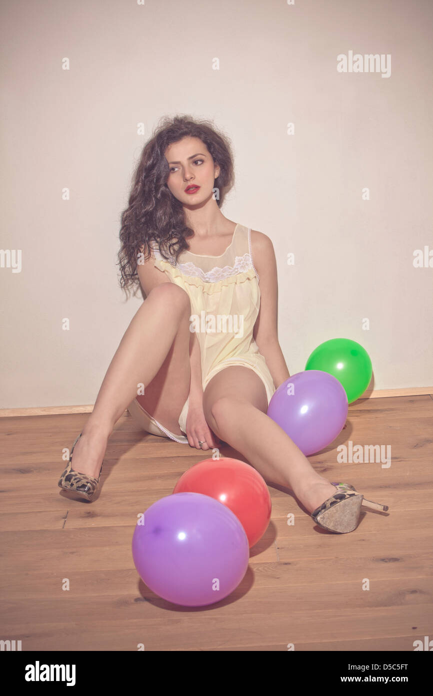 woman sitting on the floor with colorful balloons Stock Photo