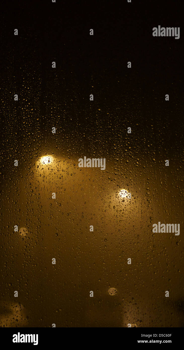 misty foggy rainy night water window street lights Stock Photo