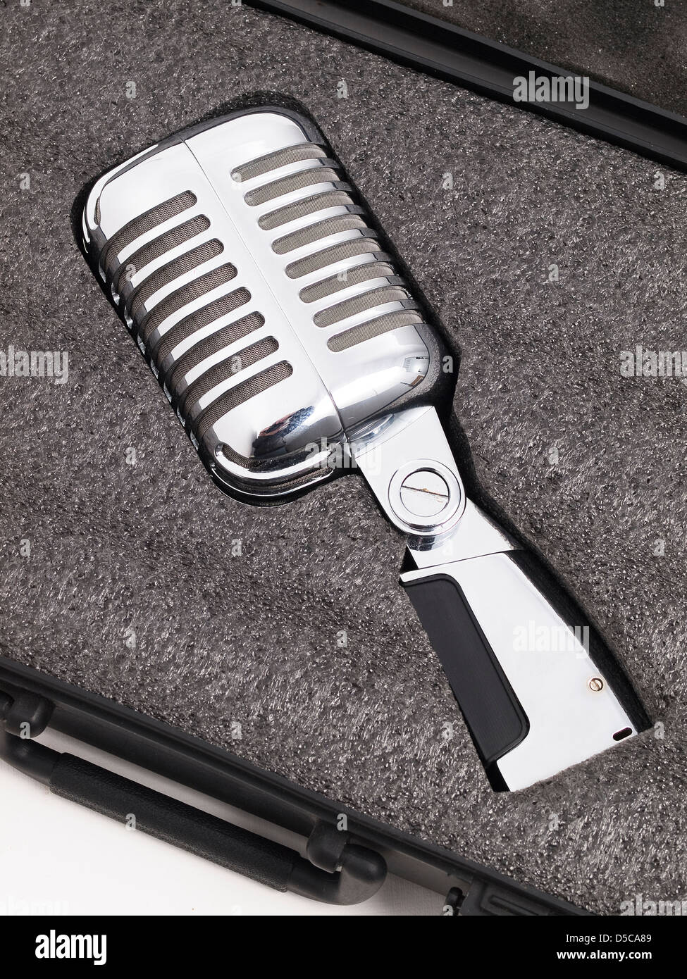 Retro microphone inside a briefcase. The microphone is lying Stock