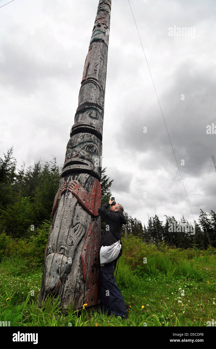 Photographing a Tlingit totem pole in Kake, Alaska. At 132' it is the tallest properly sanctioned totem pole in the world. Stock Photo