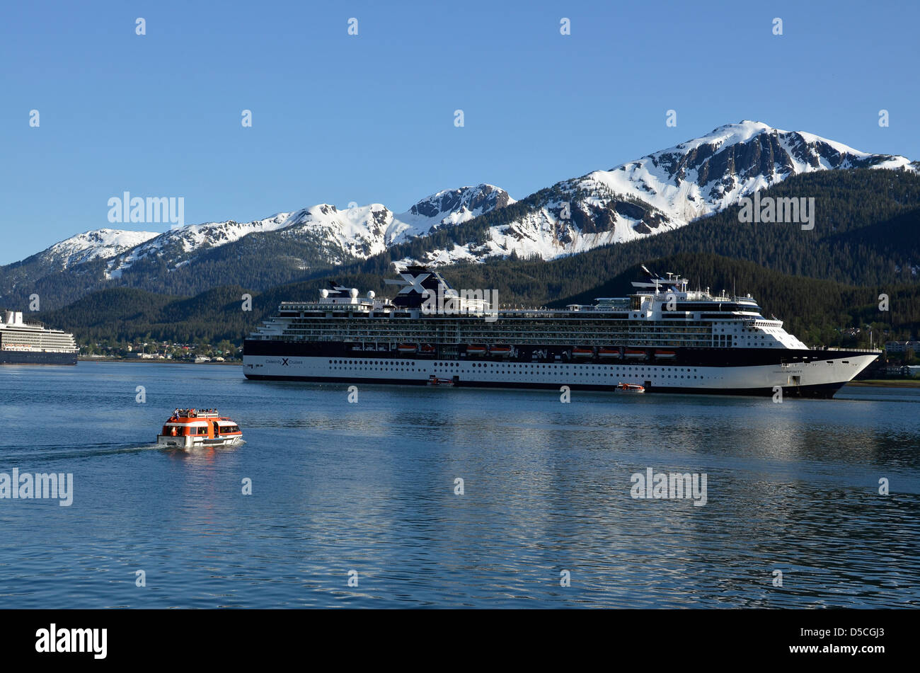 Shuttle boats ferrying tourists to cruise ship anchored in Juneau, Alaska. Stock Photo