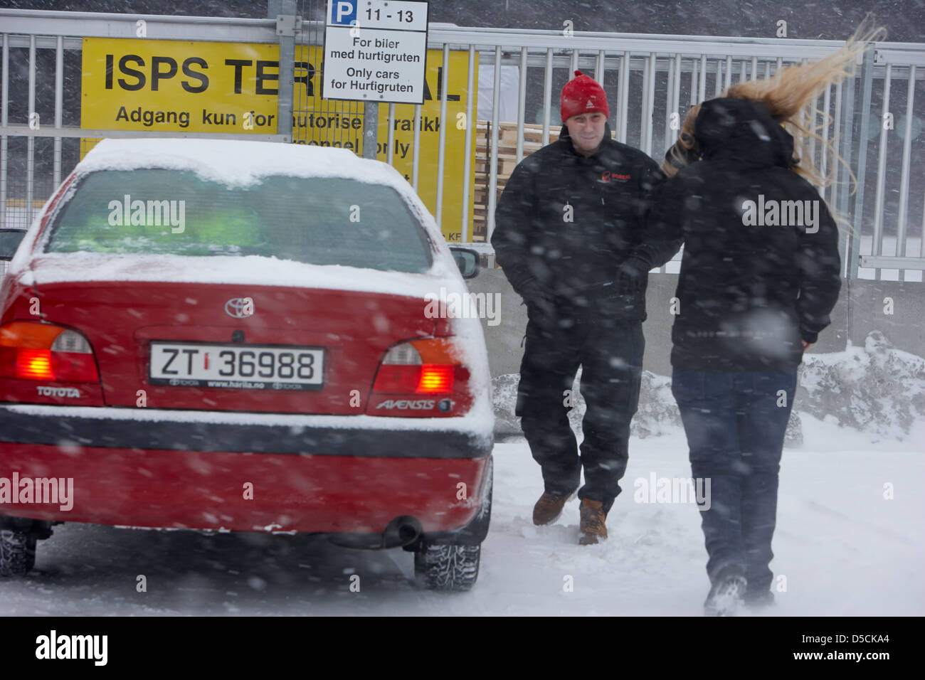 man and woman leaving car covered in snow during winter hammerfest