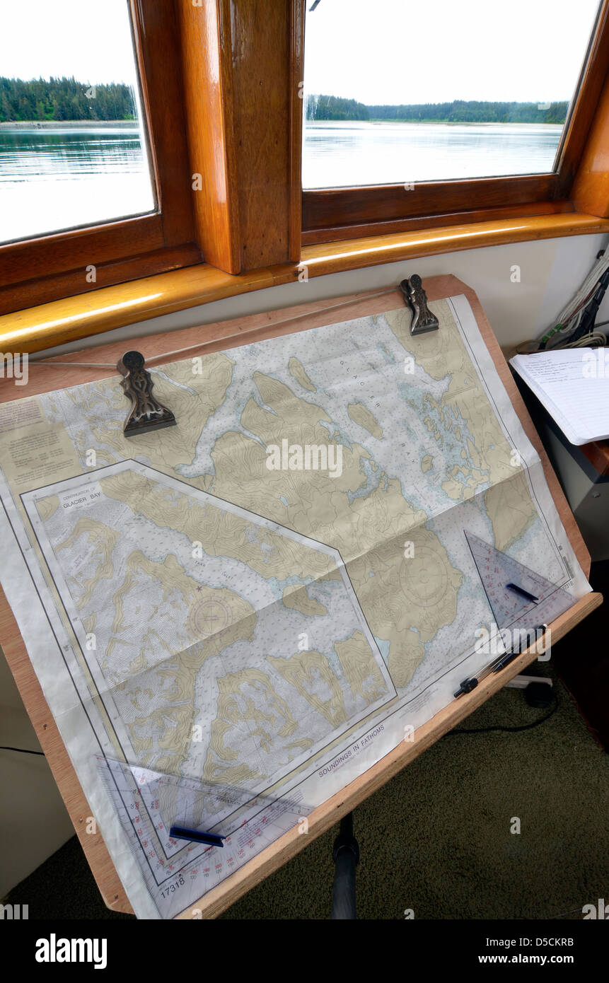 Nautical charts in the wheelhouse of a small tour boat a small tour boat in Glacier Bay, Alaska. Stock Photo