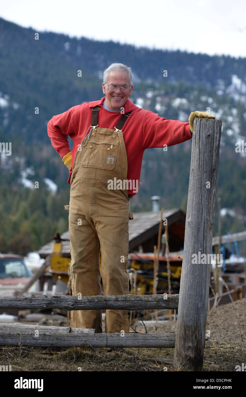 Rancher leaning against fence post, Wallowa Valley, Oregon. Stock Photo