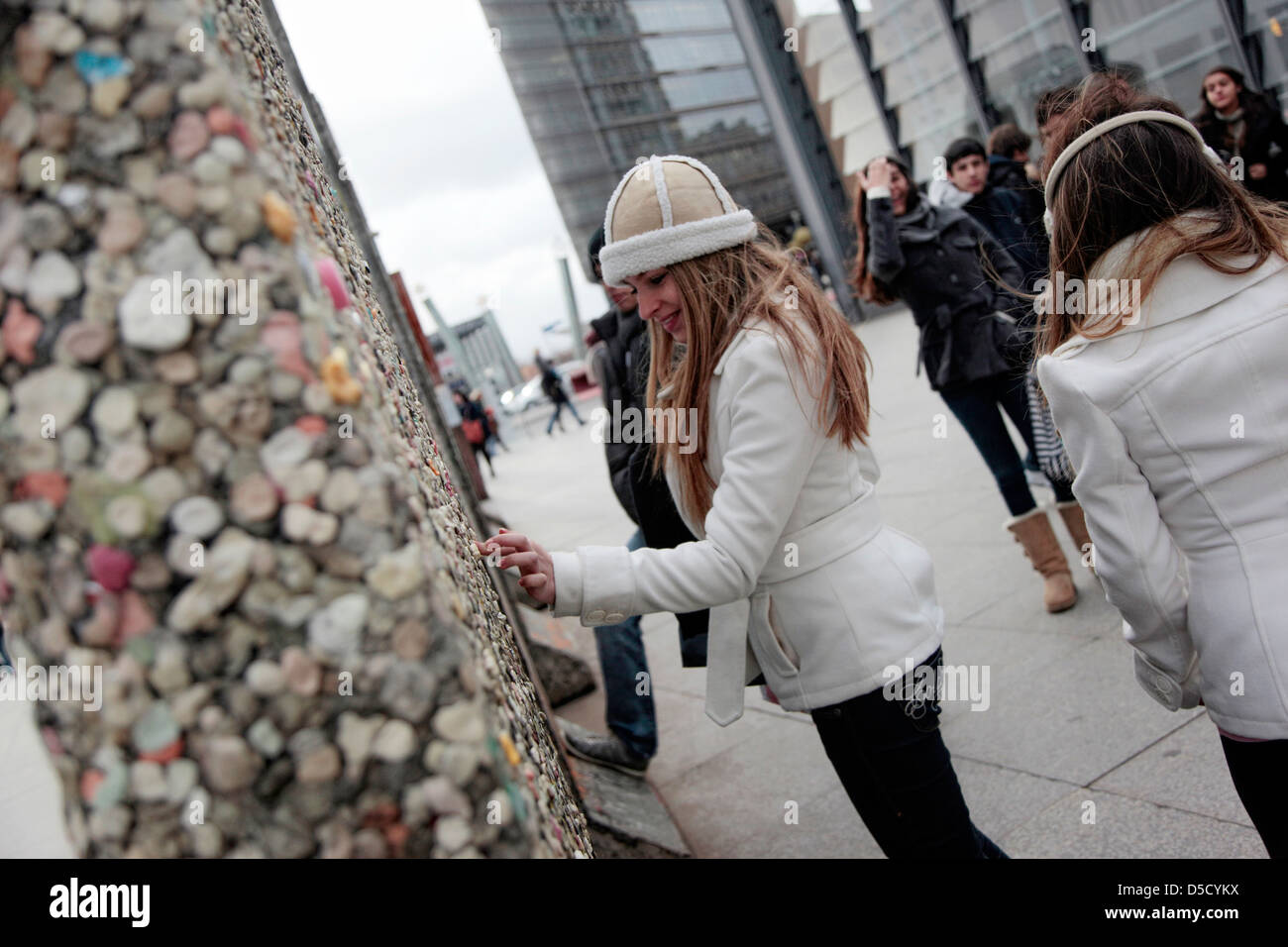 Berlin, Germany, tourists wrap the remains of the wall at Potsdamer Platz with chewing gum Stock Photo