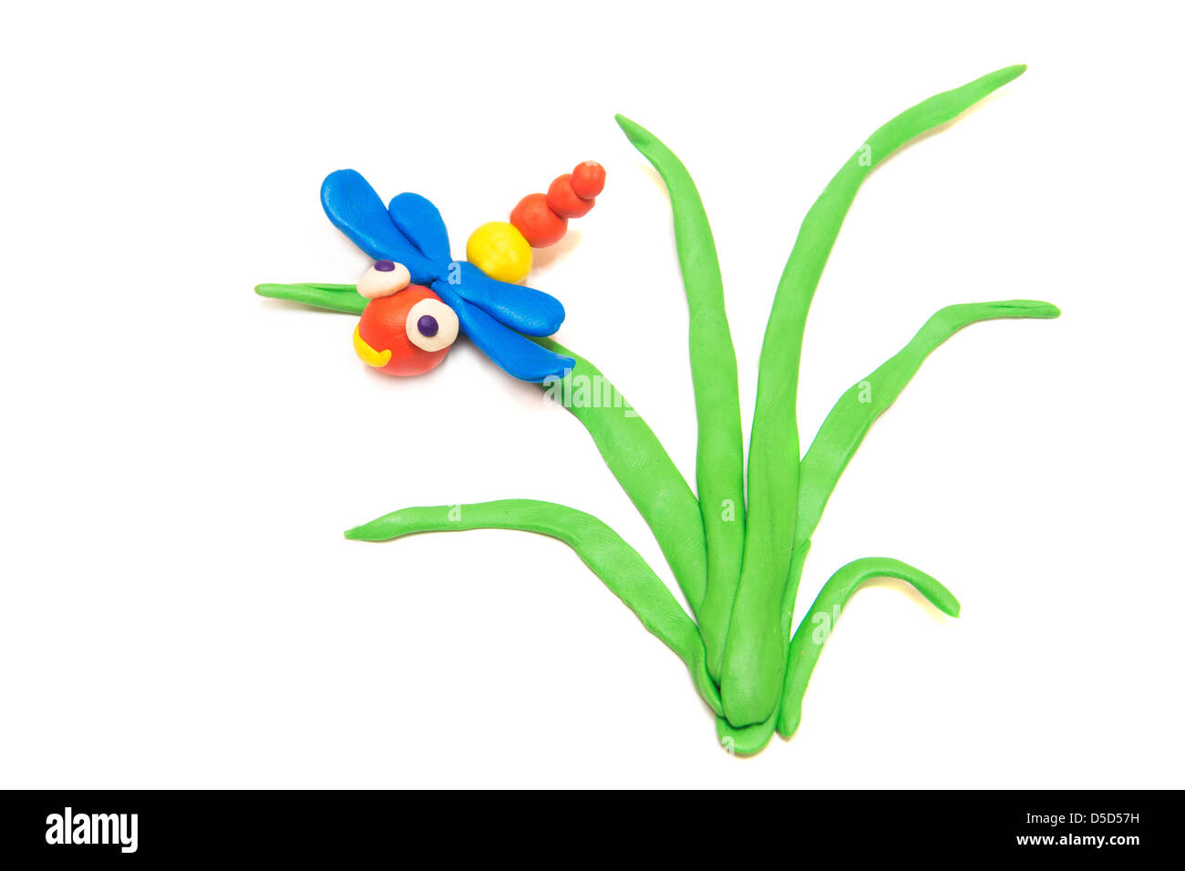 Dragonfly on grass, clay (plasticine) modeling isolated on white background. Stock Photo