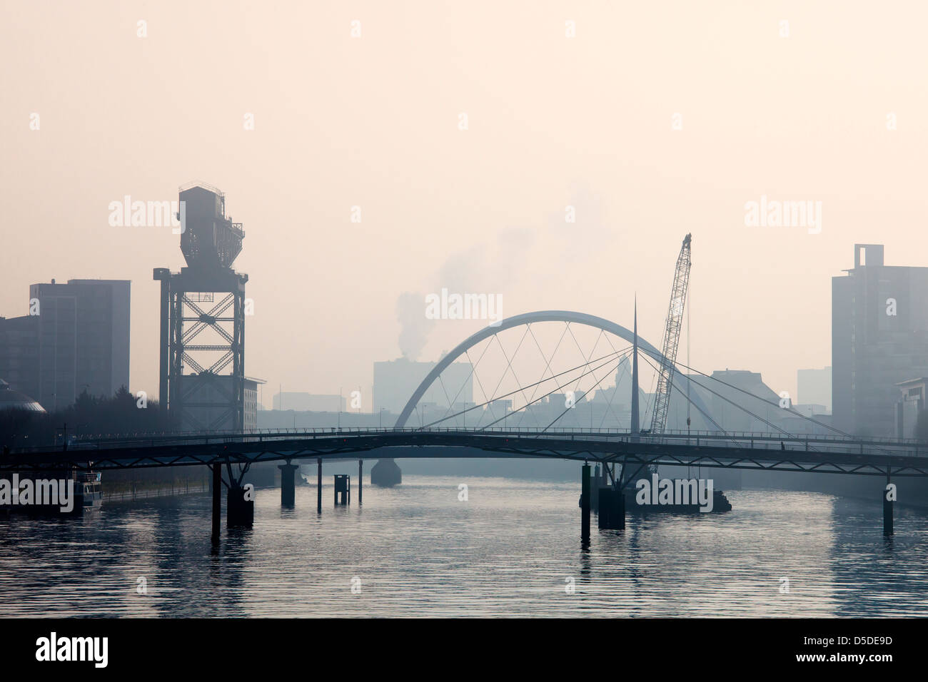 Early morning mist on the River Clyde at Finnieston and Broomielaw, showing the Bells Bridge and the Glasgow Arc, Scotland Stock Photo