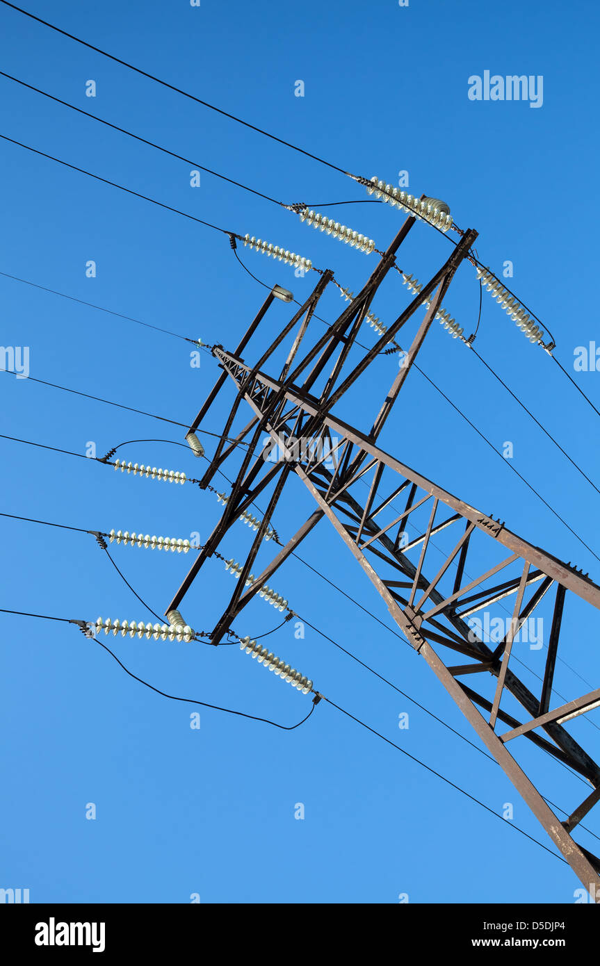 High voltage power lines and steel pylon in front of clear blue sky Stock Photo