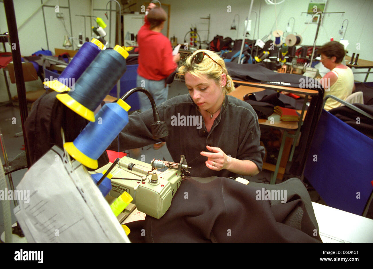 A machinist stitching together a wetsuit. Stock Photo