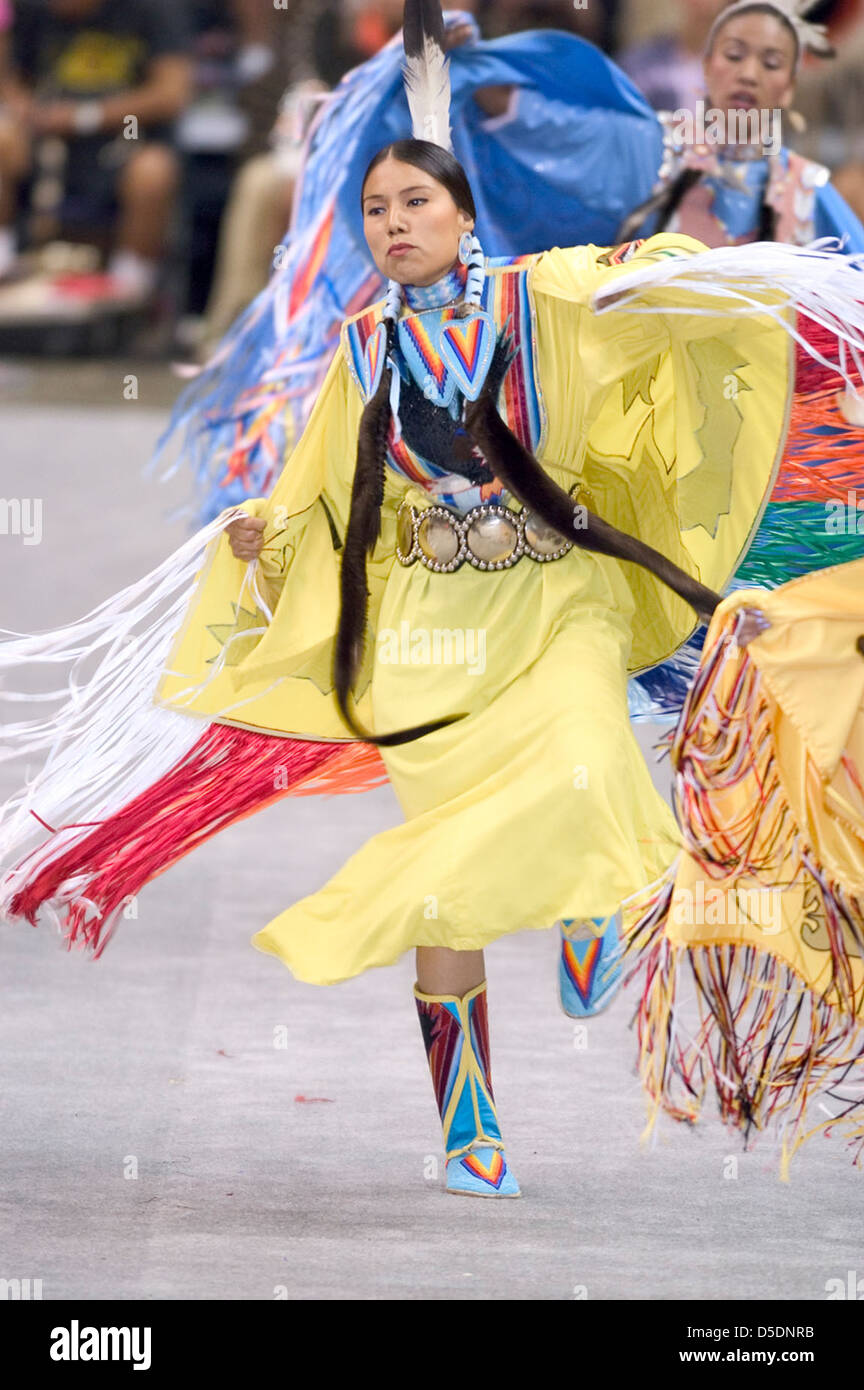 A Native American woman in yellow dances at a 2005 powwow, celebrating ...